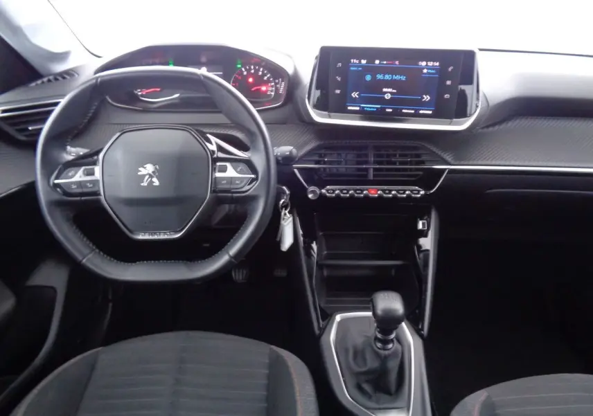 Intérieur Peugeot 208 2020 vu de face, tableau de bord moderne avec écran tactile et volant compact noir.