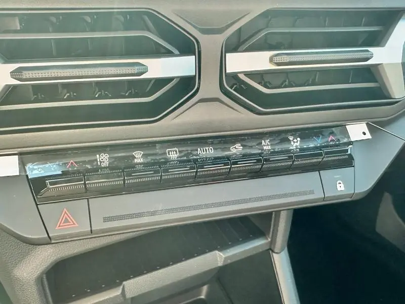 Détail de la console centrale noire avec commandes climatisation tactile du Dacia Bigster blanc 2025.