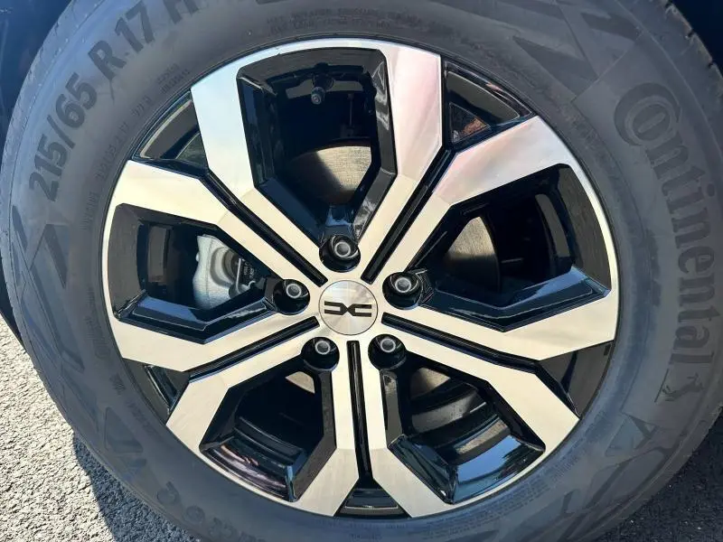 Gros plan sur la jante alu bicolore noir et argent du Dacia Bigster blanc 2025 avec pneu Continental 215/65 R17