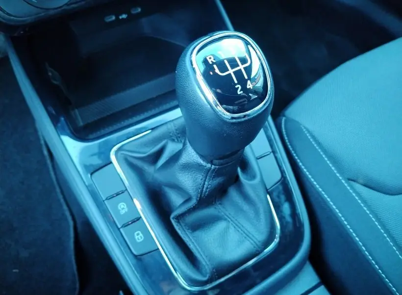 Gros plan sur le levier de vitesse manuel noir de la Skoda Fabia 2023, avec sellerie tissu gris visible à droite.