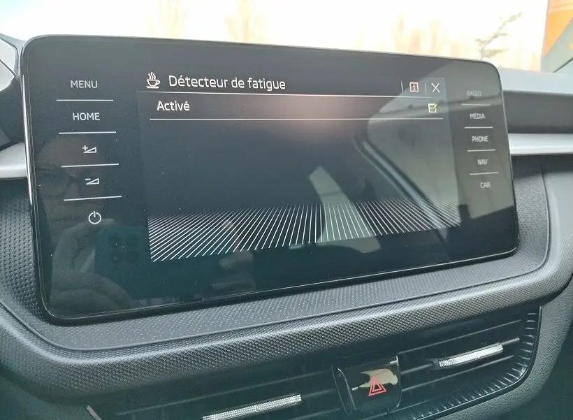 Écran tactile central de la Skoda Fabia 2023 montrant l'activation du détecteur de fatigue, intérieur noir et gris.