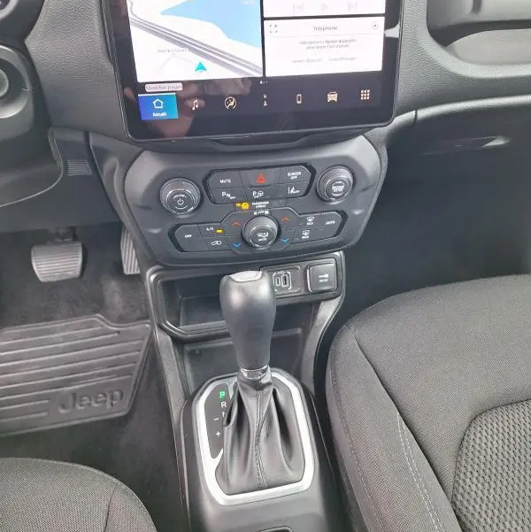 Vue rapprochée de la console centrale et levier de vitesse d'une Jeep Renegade 2024 avec écran tactile et commandes climatisation.
