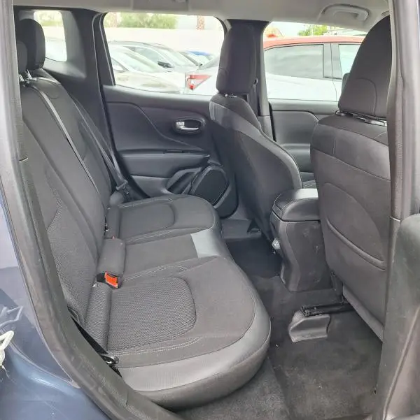 Vue intérieure côté gauche montrant les sièges arrière noirs du Jeep Renegade bleu 2024, avec accoudoir central et espace passagers.