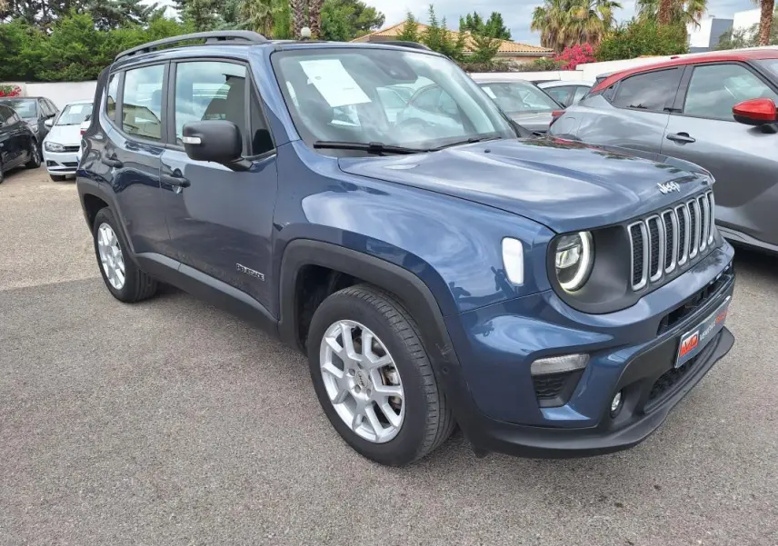 Jeep Renegade bleu en 3/4 avant droit, avec barres de toit et jantes alliage 17 pouces visibles.