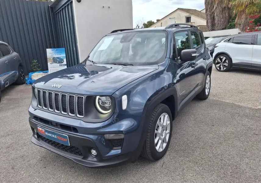 Jeep Renegade bleu en 3/4 avant droit, avec barres de toit et jantes alliage 17 pouces visibles.