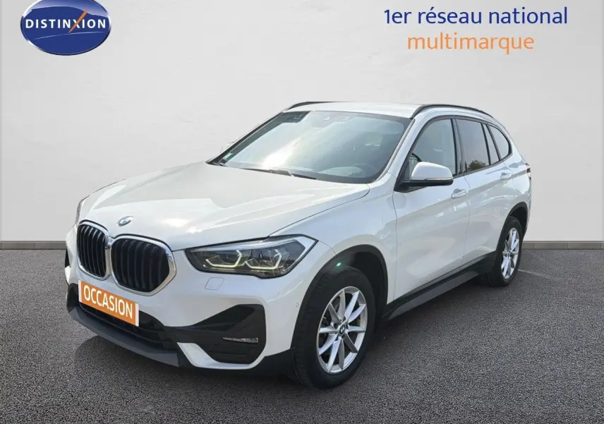 BMW X1 blanc en vue 3/4 avant droit, avec calandre noire et jantes alliage 17 pouces visibles.