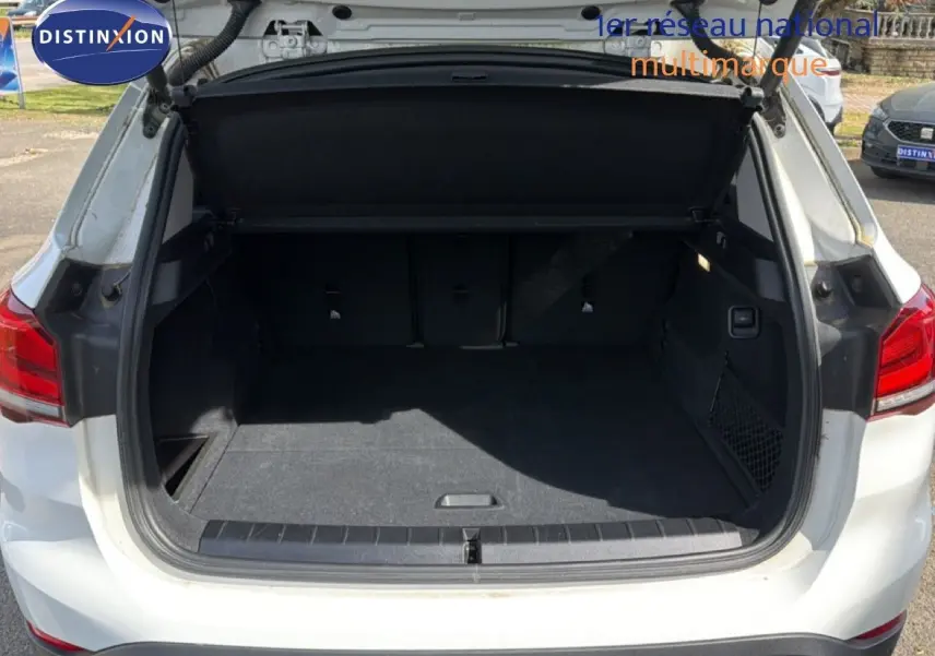 Coffre ouvert d'un BMW X1 blanc 2022 vu de l'arrière, montrant un espace de chargement spacieux et propre.