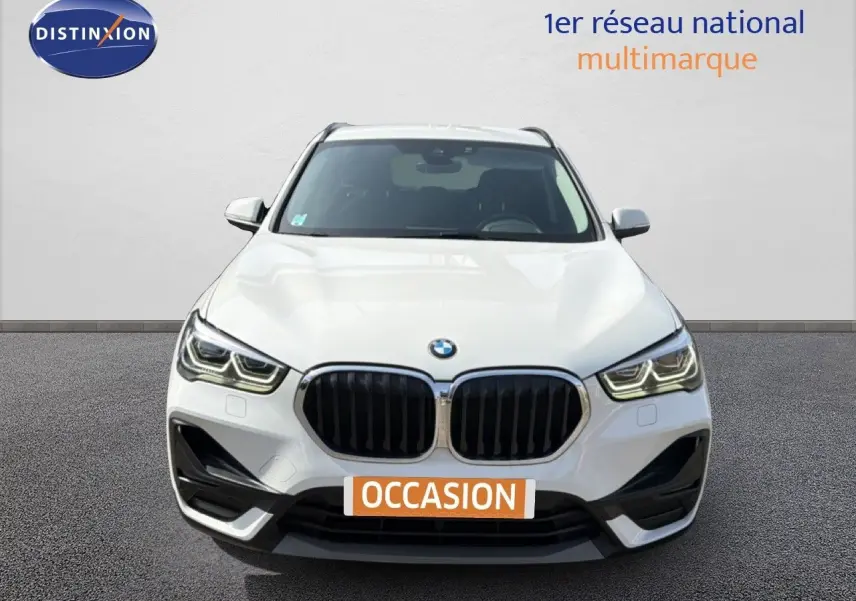 BMW X1 blanc vue de face mettant en valeur la calandre noire et les phares LED distinctifs.