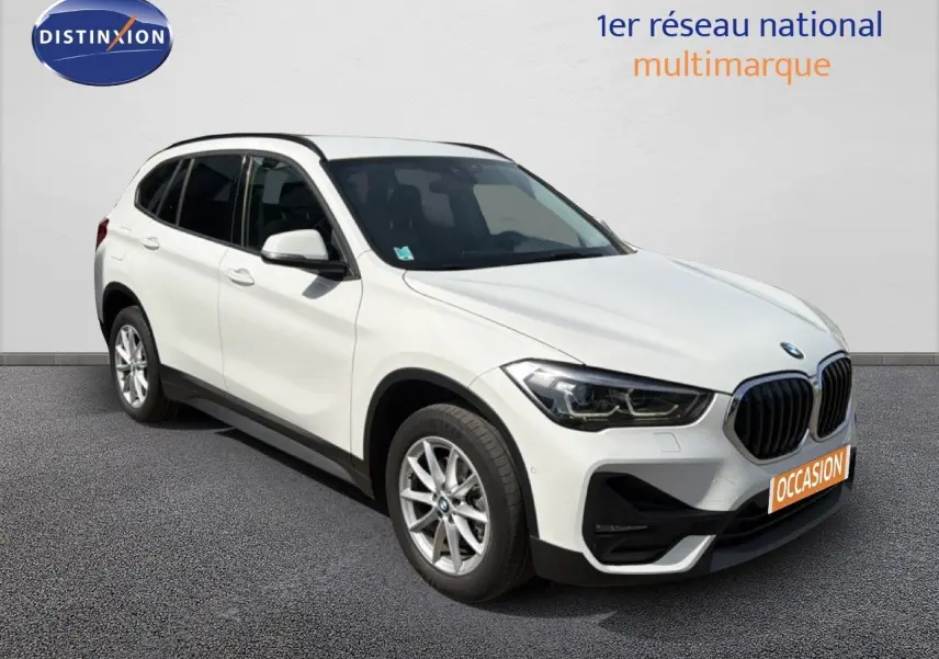 BMW X1 blanc en vue 3/4 avant droit, mettant en valeur sa calandre distinctive et ses jantes alliage.