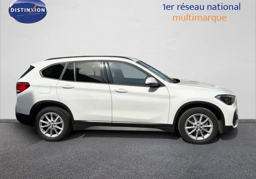 Profil droit d’un BMW X1 blanc 2022 avec jantes alliage et vitres teintées, sur fond neutre extérieur.