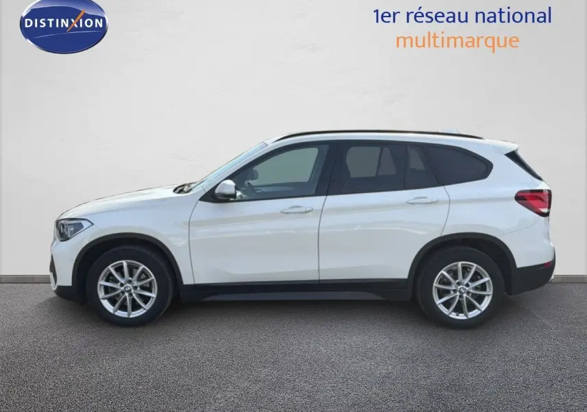 BMW X1 blanc vue de profil côté gauche, soulignant ses jantes alliage et sa silhouette compacte SUV.