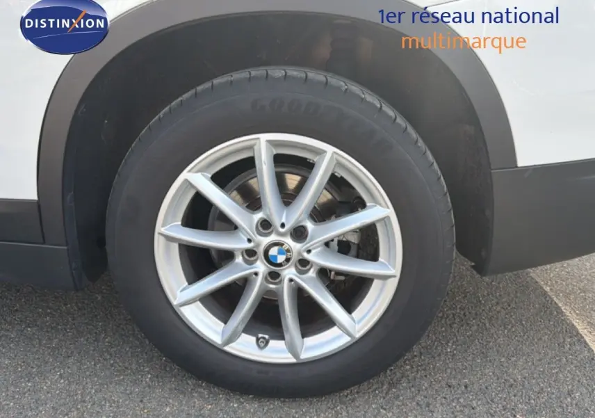 Gros plan sur la roue avant droite d’un BMW X1 blanc avec jante alliage 17 pouces et pneu Goodyear.