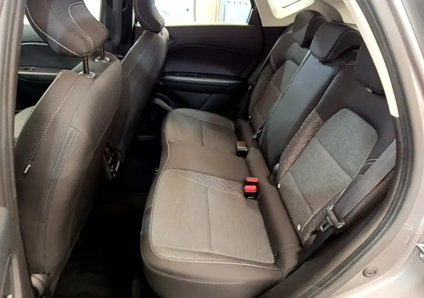 Vue intérieure côté droit montrant la banquette arrière grise du Renault Captur Zen E-Tech hybride 2022 avec ceintures de sécurité.