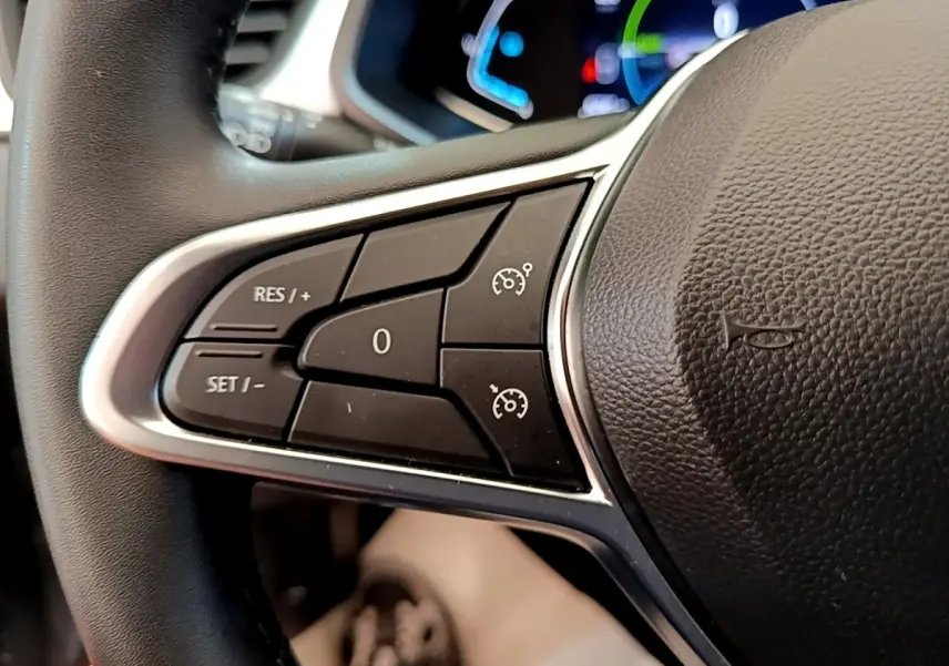 Gros plan sur les commandes du régulateur de vitesse au volant cuir du Renault Captur Zen E-Tech hybride 2022.