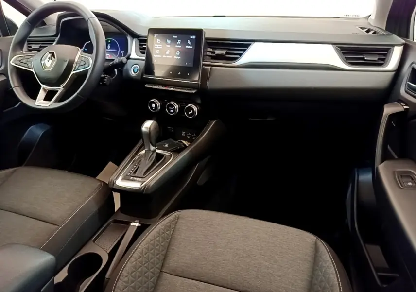 Intérieur du Renault Captur Zen E-Tech 2022 vu de l'avant, tableau de bord moderne avec écran tactile central et volant multifonctions.