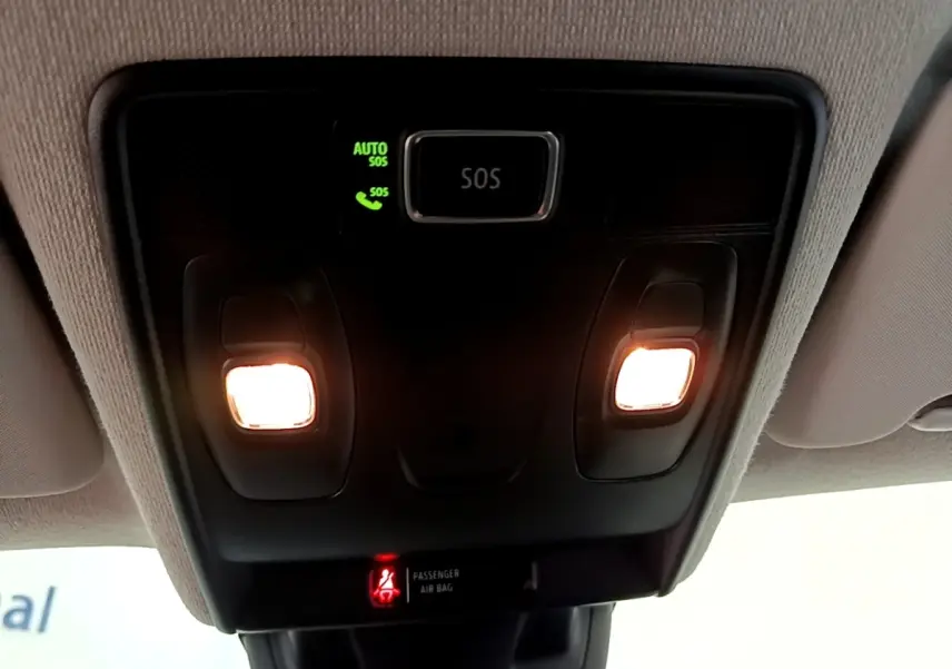 Gros plan sur la console de toit intérieure du Renault Captur gris foncé, avec éclairages et bouton SOS allumé.