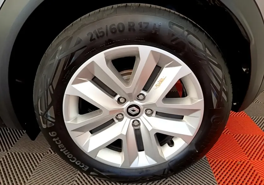 Gros plan sur la roue avant gauche du Renault Captur gris foncé, mettant en valeur la jante alliage et le pneu Continental.