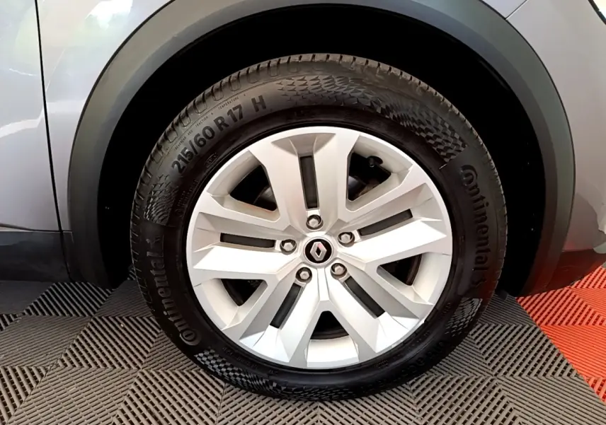 Gros plan sur la roue avant gauche du Renault Captur gris foncé, mettant en valeur la jante alliage et le pneu Continental.