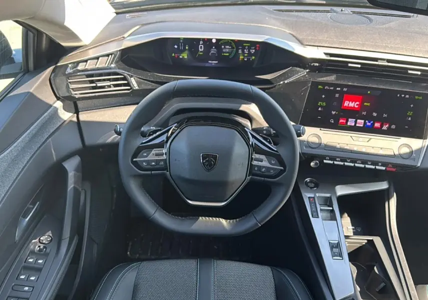 Vue intérieure frontale du tableau de bord noir et volant cuir du Peugeot 408 Hybrid 145 allure e-dcs6 2025.