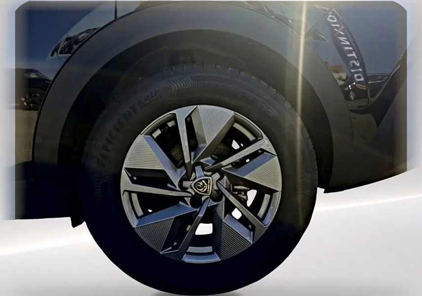 Gros plan sur la jante alu noire et grise du côté gauche d'une Peugeot 408 Hybrid 145 allure e-dcs6 noire 2025.