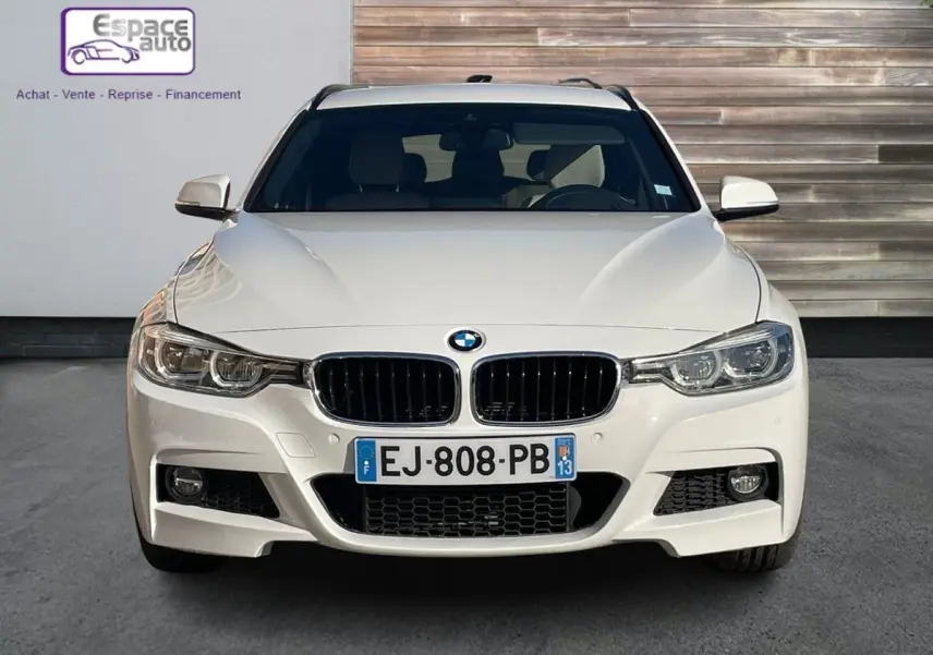 Vue frontale d'une BMW Série 3 Touring F31 blanche de 2017 avec calandre noire et phares LED distinctifs.