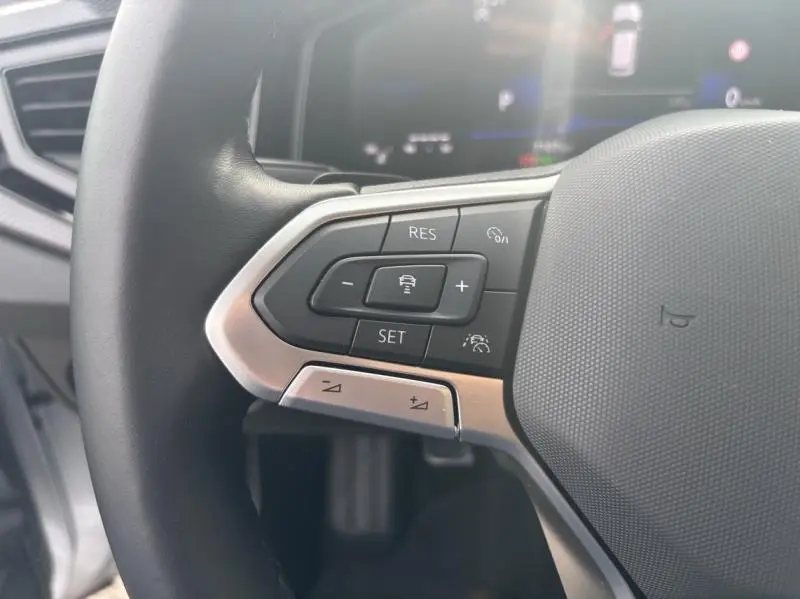 Gros plan sur les commandes multifonctions à gauche du volant cuir du Volkswagen Taigo 2025 couleur Reflet d'Argent.
