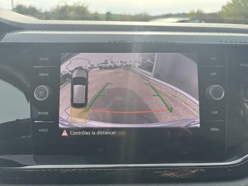 Écran tactile du système multimédia affichant la caméra de recul du Volkswagen Taigo Reflet d'Argent, vue arrière en stationnement.