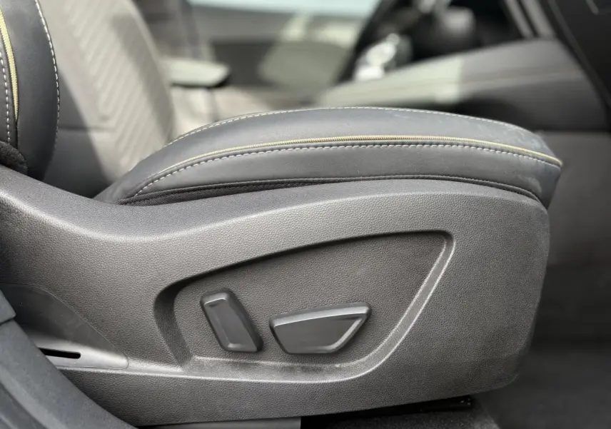 Gros plan sur les commandes électriques du siège conducteur en cuir noir de la Renault Symbioz 2025.