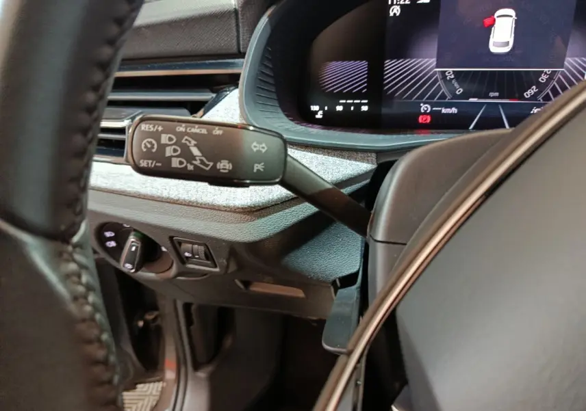 Vue rapprochée du tableau de bord et du commodo gauche d’un Skoda Kamiq 2024, intérieur noir avec affichage numérique.