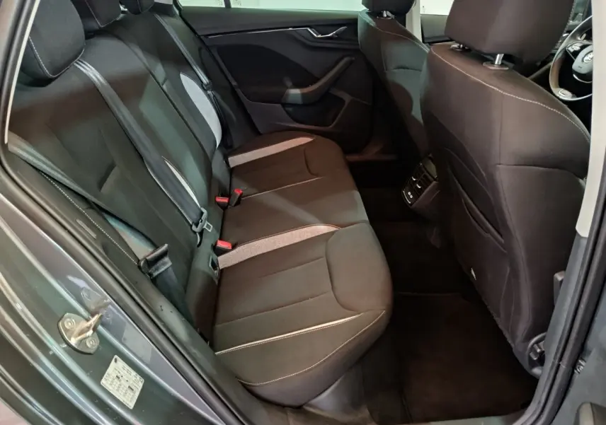 Vue intérieure côté gauche sur la banquette arrière noire avec inserts gris du Skoda Kamiq gris clair 2024.