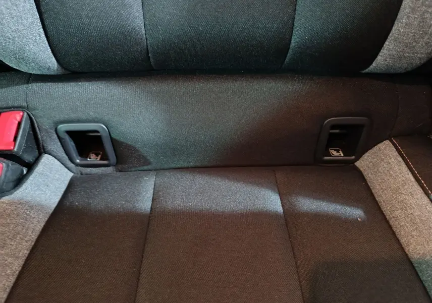 Gros plan sur la banquette arrière gris foncé du Skoda Kamiq 2024 avec fixation Isofix et ceintures rouges.