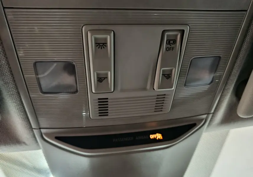 Vue en plongée du plafonnier gris clair du Skoda Kamiq 2024 avec commandes d'éclairage et témoin airbag passager éteint.