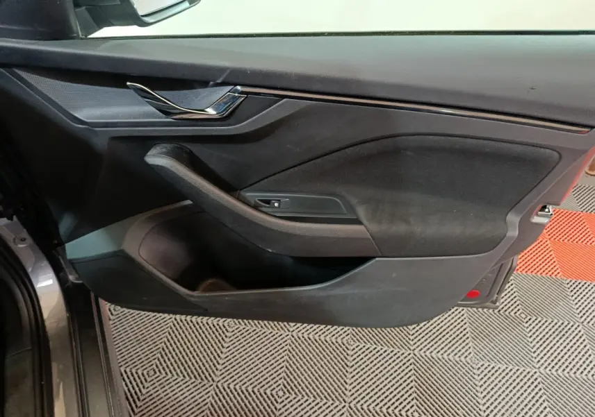 Vue intérieure côté gauche de la porte avant gris clair du Skoda Kamiq 2024 avec poignée et commande de vitre.