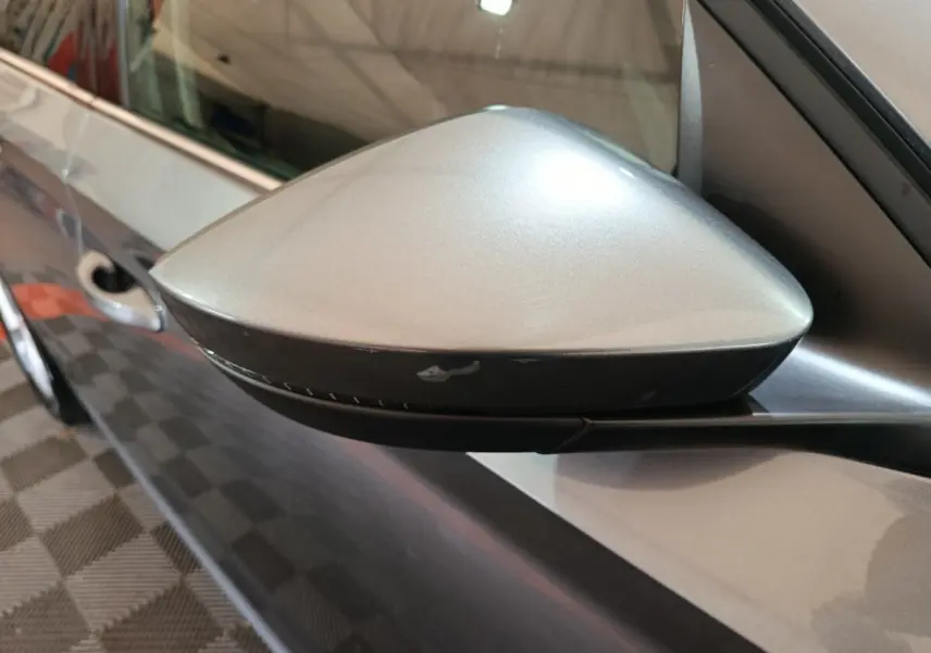 Rétroviseur côté conducteur gris clair du Skoda Kamiq 2024, vue rapprochée sur la portière et poignée.