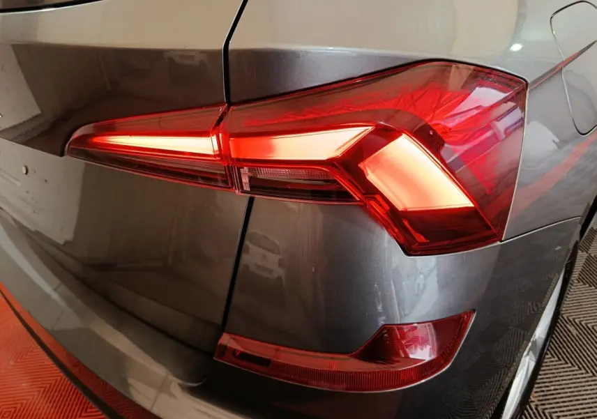 Gros plan sur le feu arrière droit rouge du Skoda Kamiq gris clair 2024, mettant en valeur ses lignes angulaires modernes.