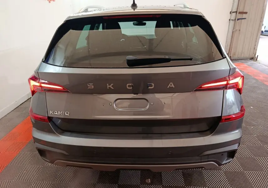 Vue arrière d'un Skoda Kamiq gris clair avec feux LED allumés dans un garage intérieur.