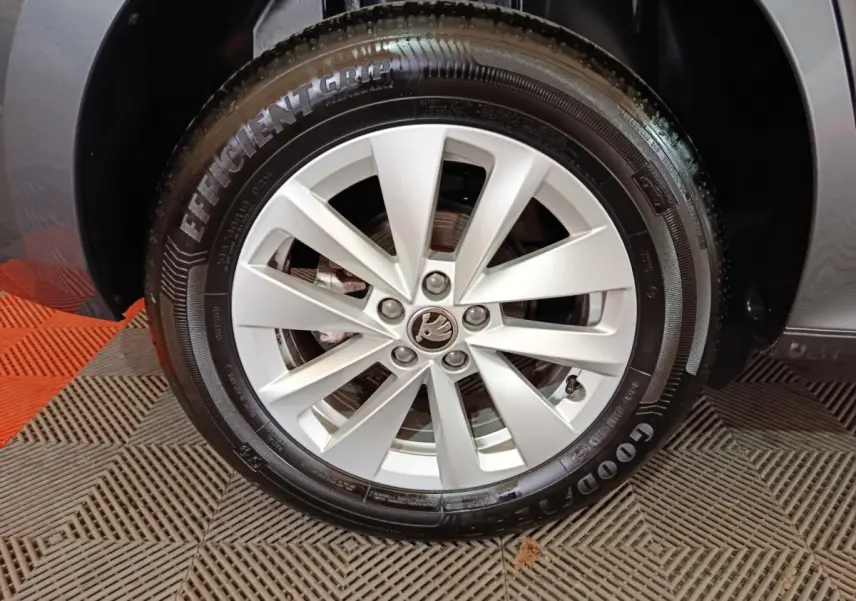 Gros plan sur la roue avant droite d’un Skoda Kamiq gris clair, avec jante alliage et pneu Goodyear.