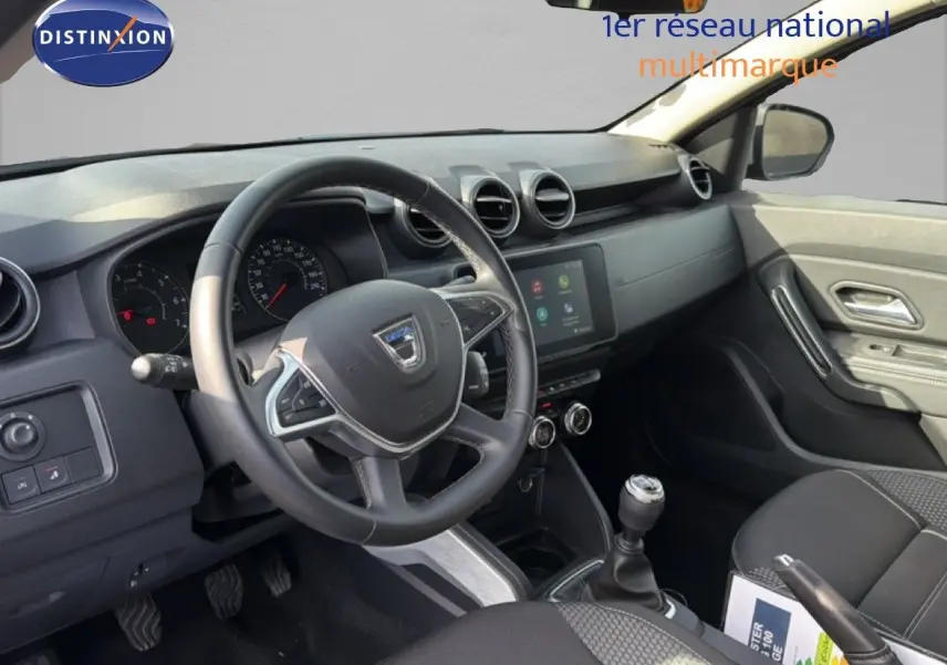 Vue intérieure côté conducteur du Dacia Duster 1.0 ECO-G 100 Prestige 2022, tableau de bord et volant noirs.