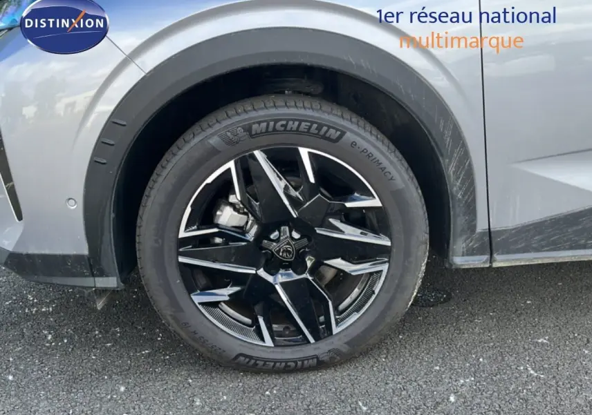 Gros plan sur la roue avant gauche du Peugeot 5008 gris Artense métal avec jante noire et détails chromés.