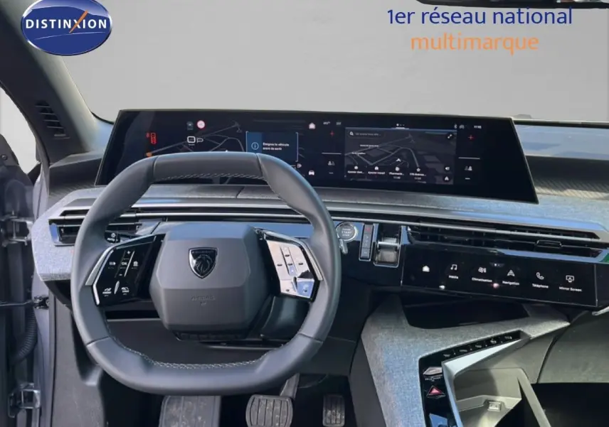 Vue intérieure du tableau de bord et volant de la Peugeot 5008 gris Artense, avec écran tactile panoramique et commandes intégrées.