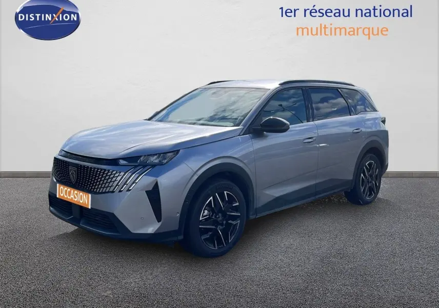 Peugeot 5008 gris Artense métal en 3/4 avant droit, avec jantes noires et calandre distinctive moderne.