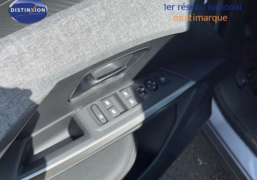 Gros plan sur la commande des vitres côté gauche d'une Peugeot 5008 gris Artense métal, intérieur tissu et cuir noir.