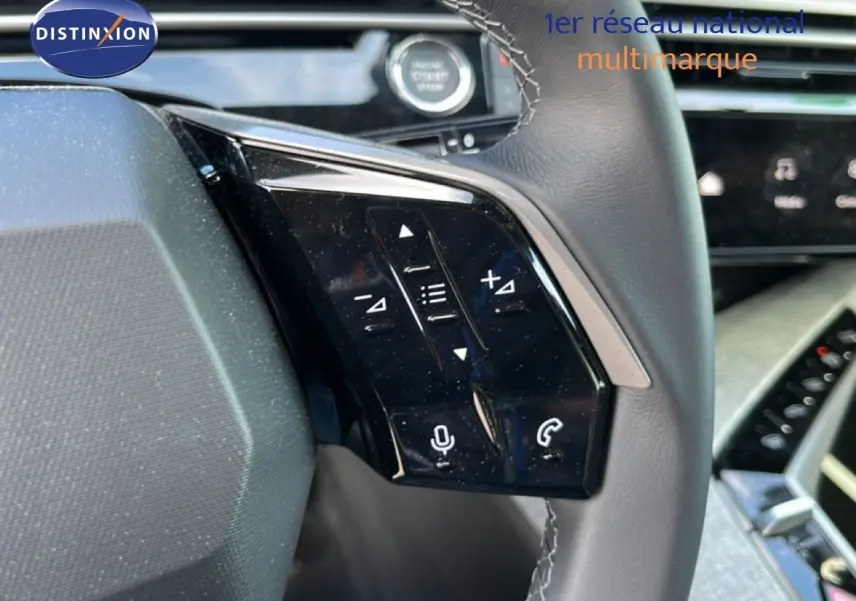 Détail du volant côté gauche du Peugeot 5008 gris Artense, avec commandes audio et téléphone intégrées.