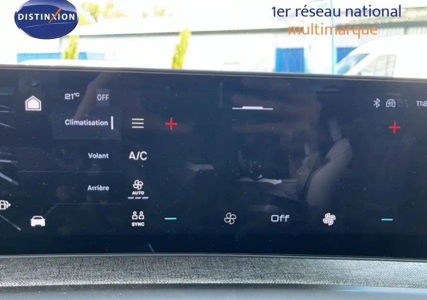 Écran tactile intérieur du Peugeot 5008 2025 affichant les réglages de climatisation, avec reflet des sièges noirs.