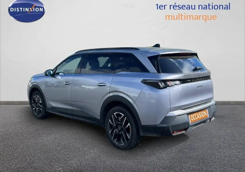 Peugeot 5008 gris Artense métal, vue 3/4 arrière droit, jantes noires et toit panoramique visible.