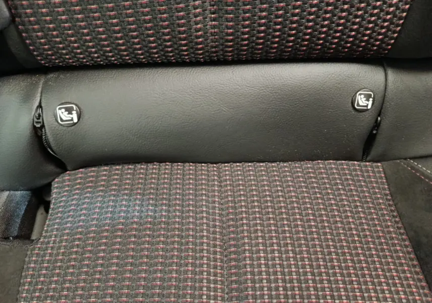 Gros plan sur la banquette arrière du DS3 2024, tissu noir à motifs rouges avec fixations Isofix visibles.