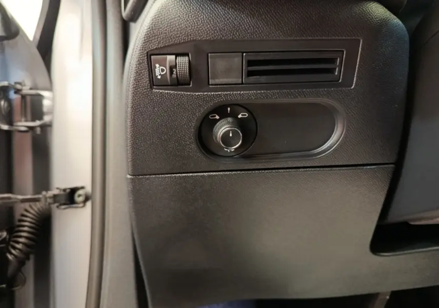 Détail du panneau de réglage des phares et ventilation côté gauche intérieur d'une DS3 1.2 PureTech 130 gris foncé 2024.