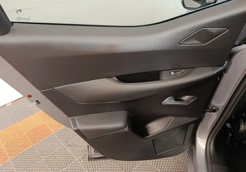Vue rapprochée de la porte avant gauche gris foncé du DS3 2024, avec poignée et commande de vitre intégrées.