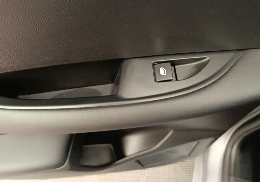Gros plan sur la commande de verrouillage de porte côté conducteur de la DS3 1.2 PureTech 130 gris foncé, intérieur noir.