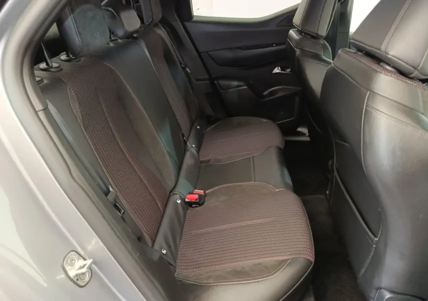 Vue intérieure côté gauche sur la banquette arrière en cuir et tissu du DS3 gris foncé, avec appuie-têtes et ceinture de sécurité visibles.